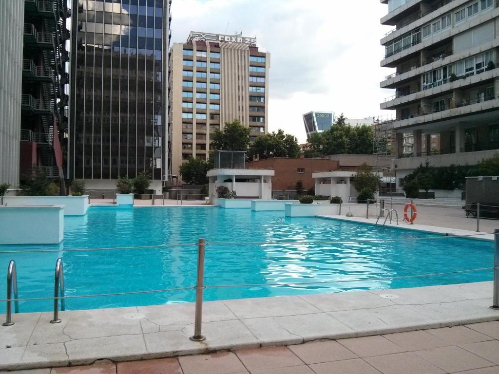 a large blue swimming pool in a city at Apartamento Calle Mauricio Legendre in Madrid
