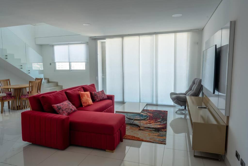 バランキージャにあるLux Duplex, unique views,Villa Santosのリビングルーム(赤いソファ、テレビ付)