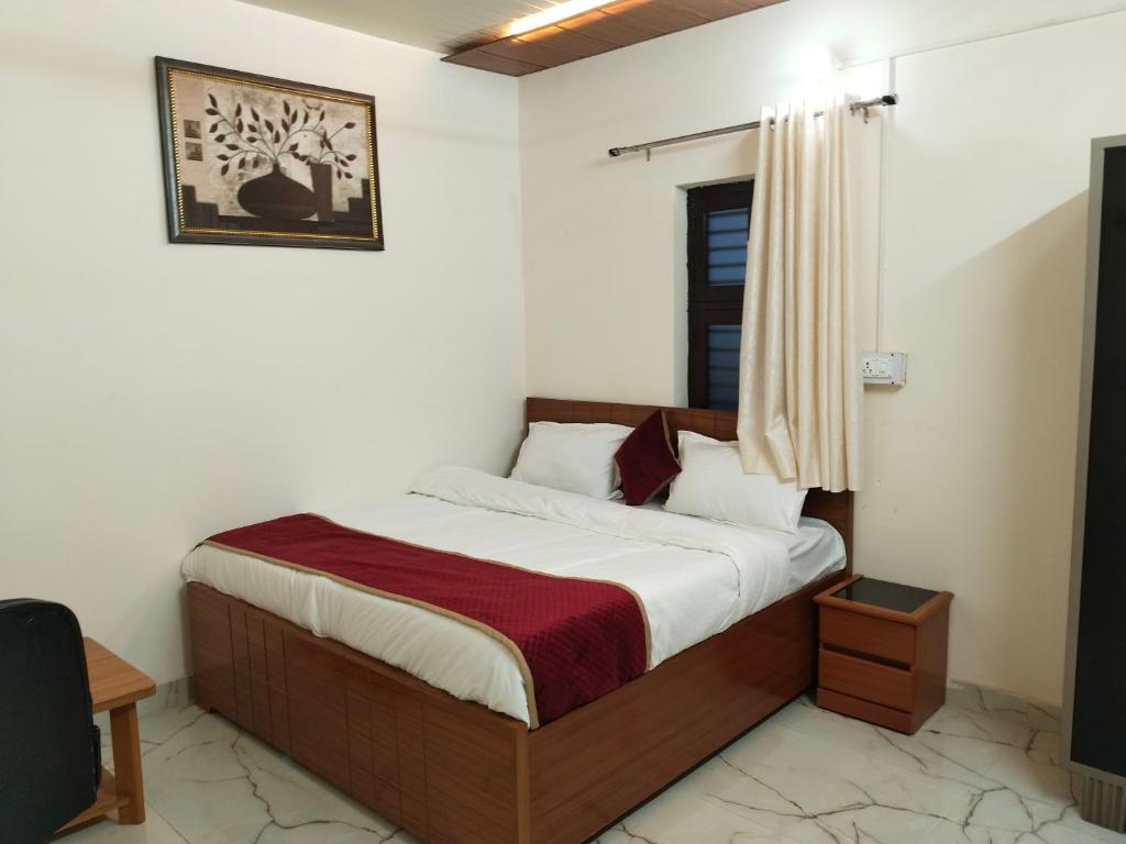 a bedroom with a bed with a red blanket at JMD 13 Hotel in Gurgaon