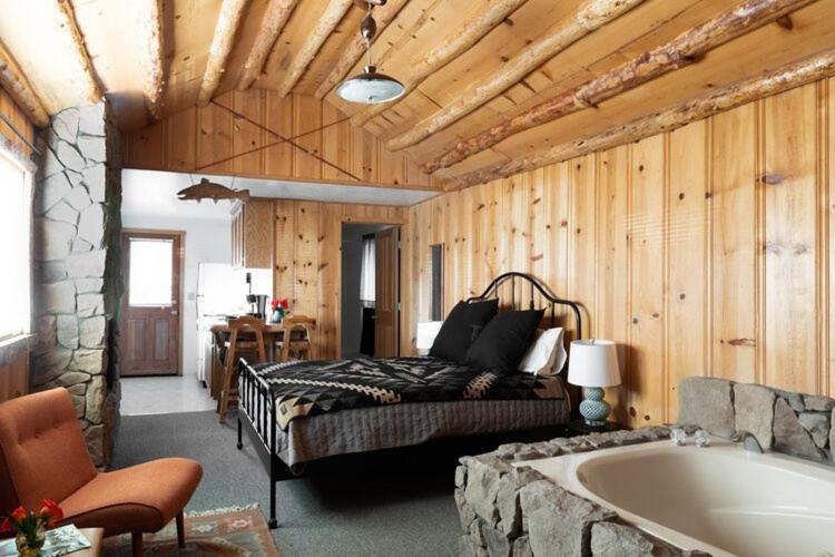 Schlafzimmer mit einem Bett und einer Badewanne in der Unterkunft 2412 - Oak Knoll Studio with Jacuzzi #15 cabin in Big Bear Lake