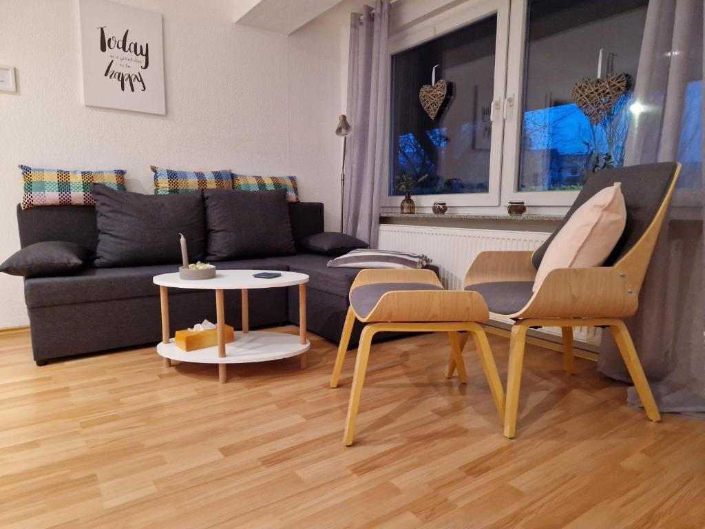 sala de estar con sofá, 2 sillas y mesa en Freundliches Apartment Helpup, en Oerlinghausen