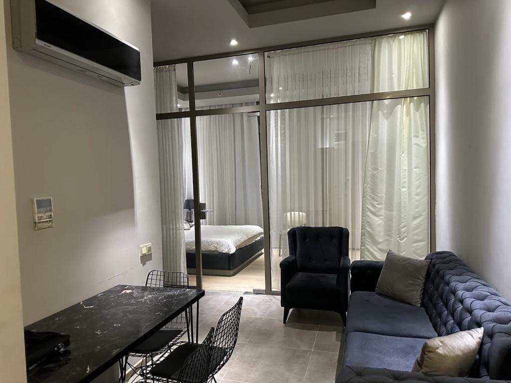 sala de estar con sofá azul y dormitorio en Soli centr apartman, en Mezitli