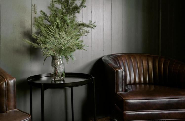 eine Vase mit einer Pflanze auf einem Tisch neben einem Stuhl in der Unterkunft 2406 - Oak Knoll #8 cabin in Big Bear Lake