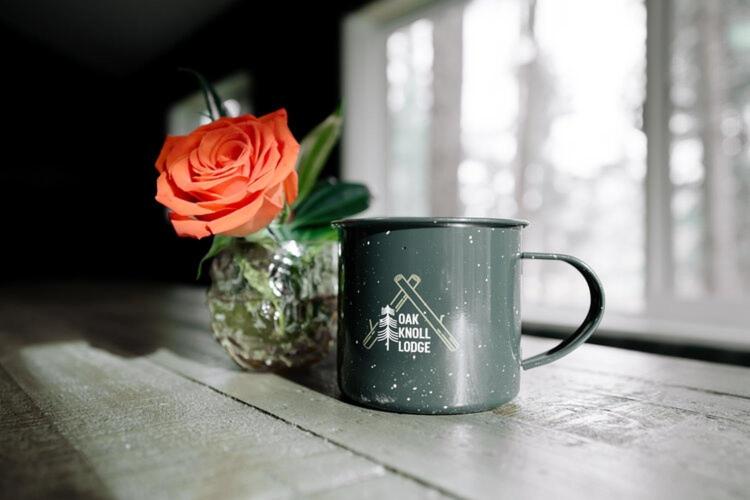 a black coffee cup with a flower in a vase at 2409 - Oak Knoll #11 cabin in Big Bear Lake