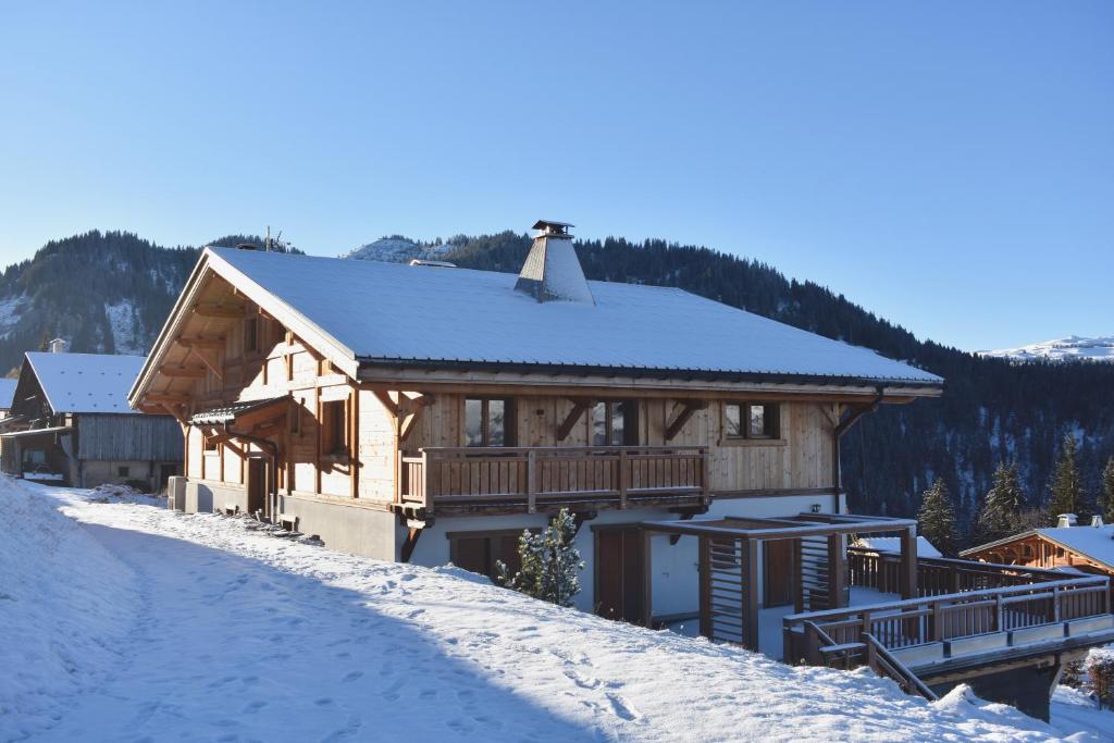 Casa de madera grande con nieve en el suelo en Charmant demi-chalet à la montagne, en Notre-Dame-de-Bellecombe