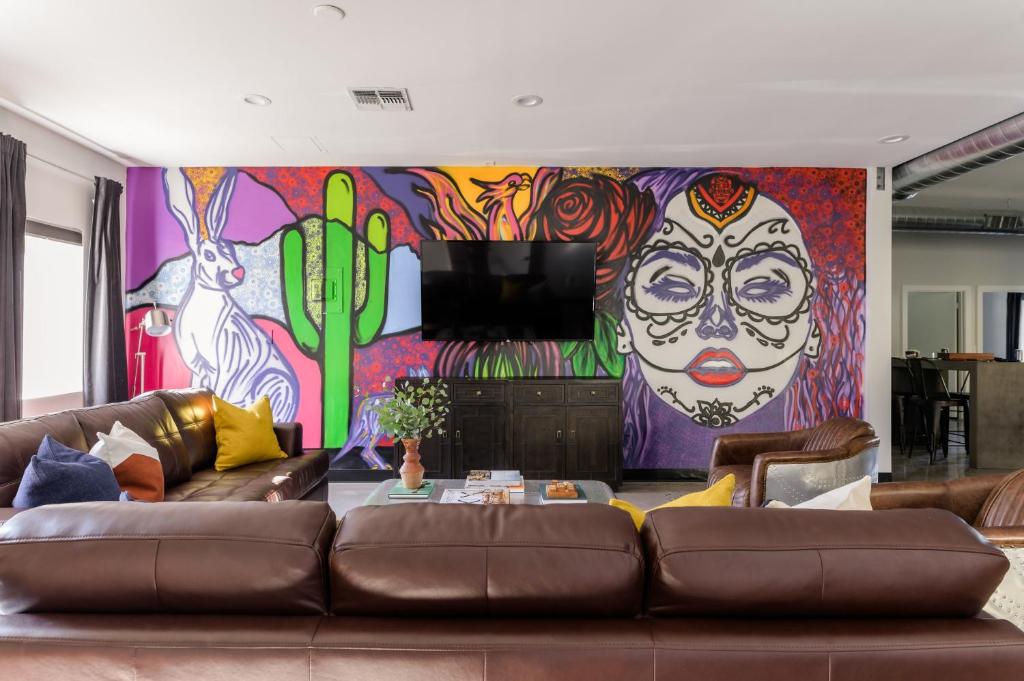 a living room with a couch and a mural at Luna Stellar by AvantStay Modern Artists Loft Buyout w 10 BRs Patio Billiards in Scottsdale