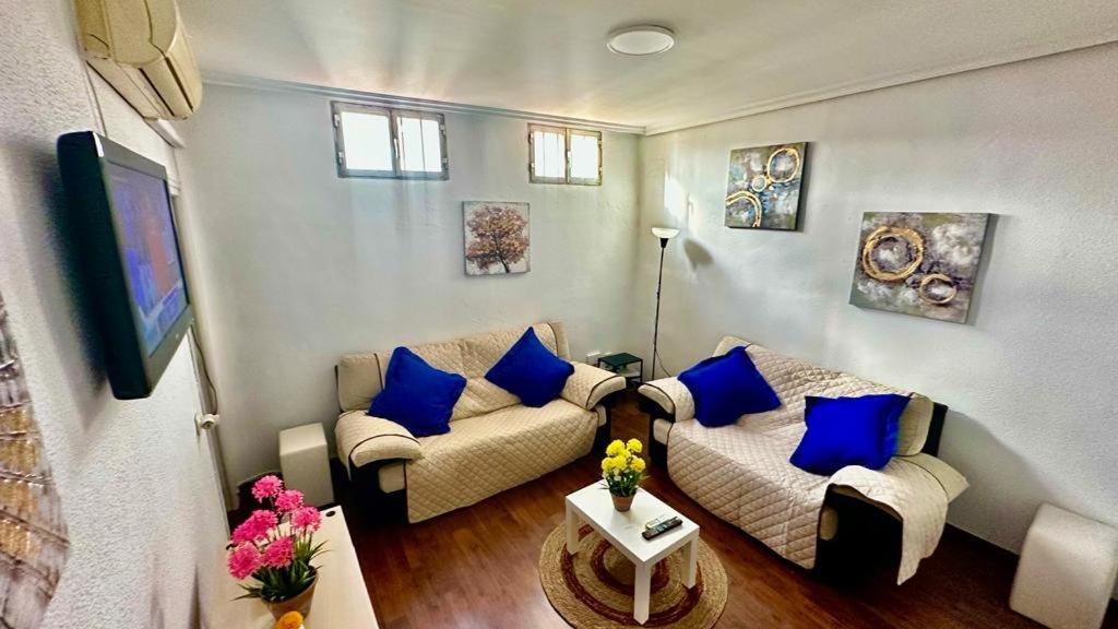 ein Wohnzimmer mit Sofa und blauen Kissen in der Unterkunft Centro Madrid in Madrid