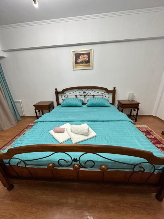 een slaapkamer met een blauw bed en 2 handdoeken bij APART 13 ALMATY in Alma-Ata