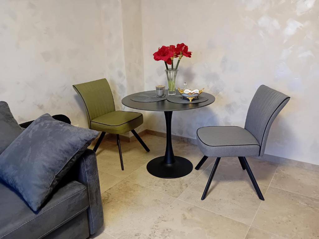 a table with a vase of flowers and a couch at Superbe T1 - 10 min centre in Schiltigheim