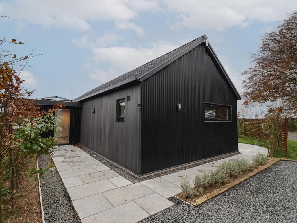 a black house with a black roof at Wren in Huggate