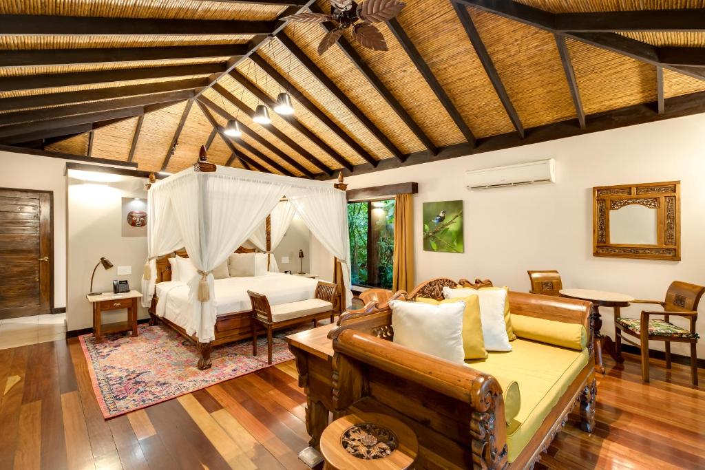 sala de estar con cama y sofá en Hideaway Rio Celeste Hotel, en Bijagua