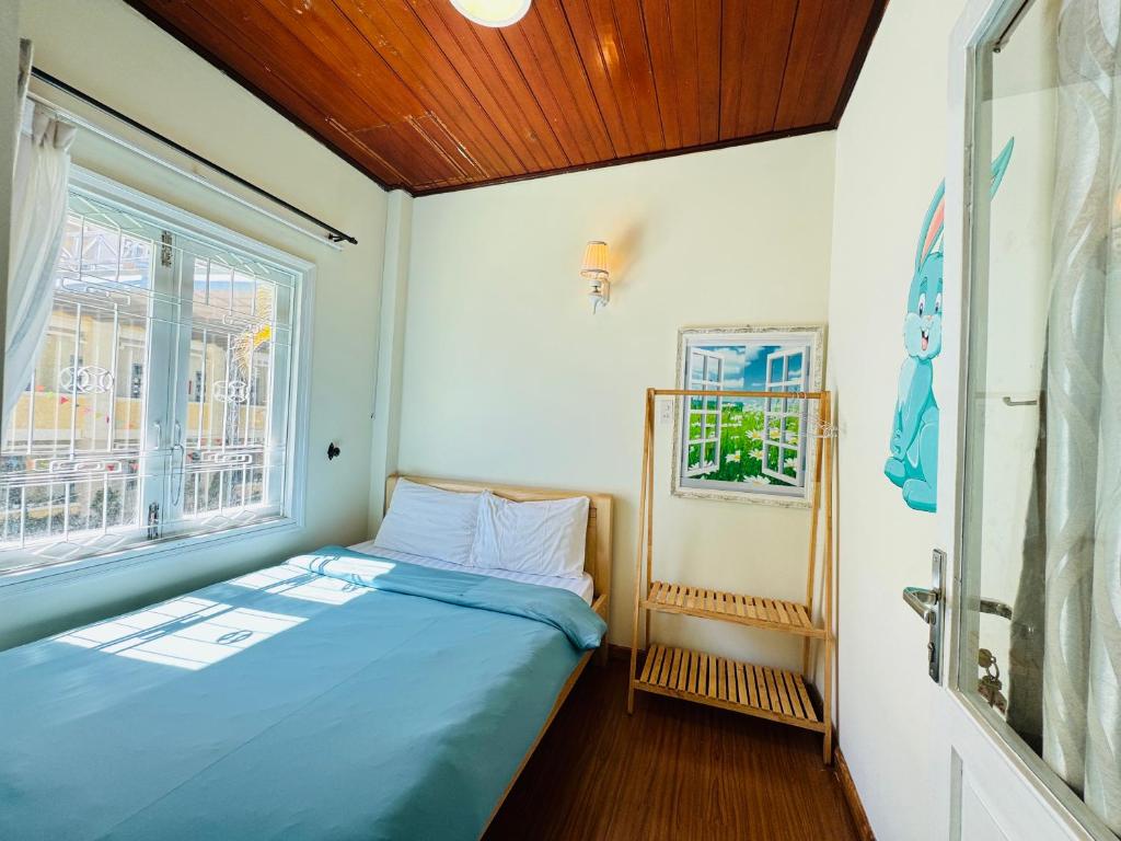 een kleine slaapkamer met een bed en een raam bij Home Thỏ Vân Anh in Da Lat