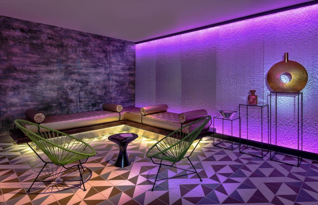 a room with a couch and chairs and purple lighting at The LINQ Hotel and Casino in Las Vegas