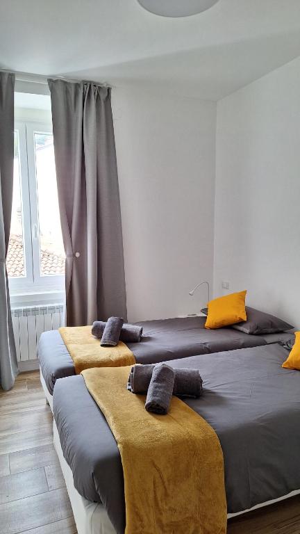 ein Schlafzimmer mit 2 Betten und gelben Kissen darauf in der Unterkunft Casa vacanze Mami in Triest