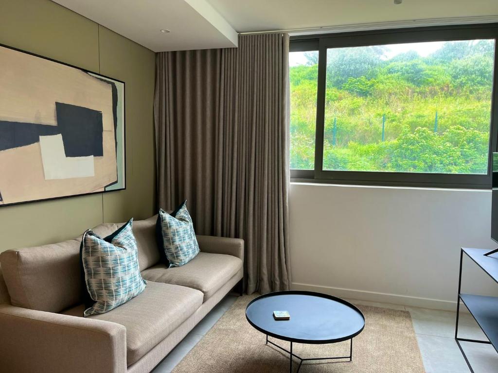 a living room with a couch and a large window at Zimbali Boulevard Suites 159 in Ballito