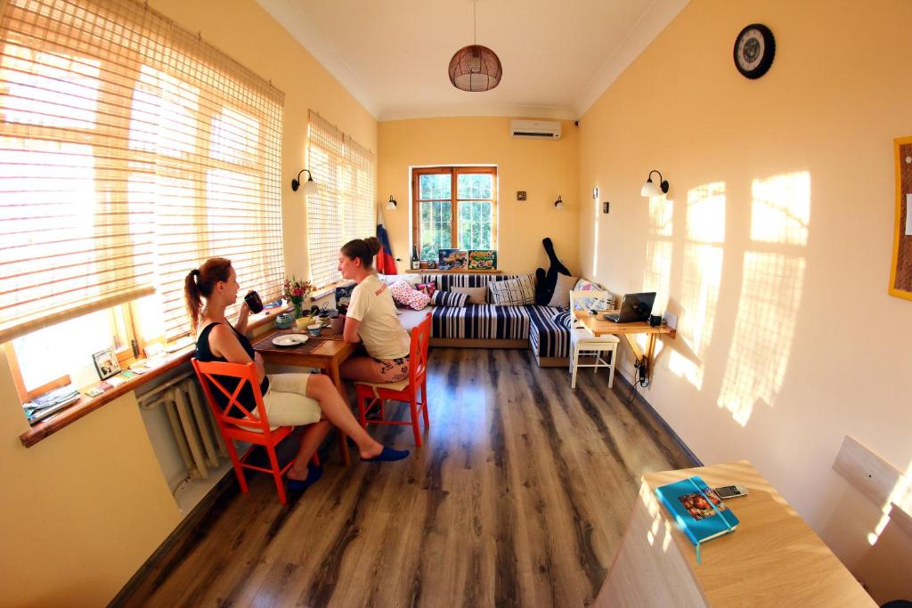 dos personas sentadas en una mesa en una sala de estar en Smile, en Sevastopol