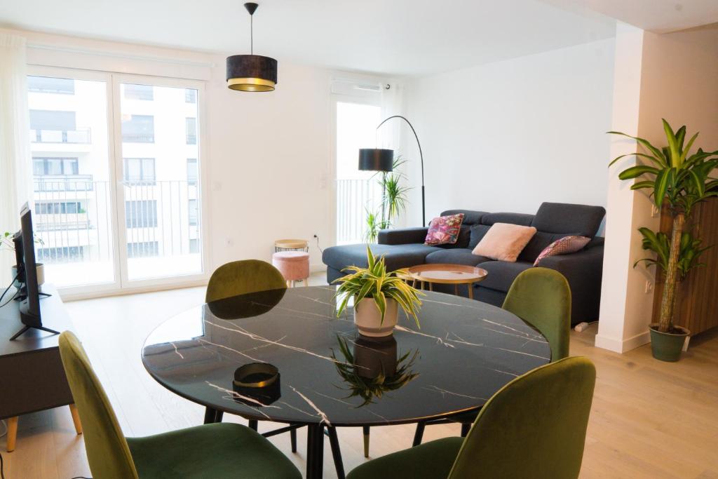 uma sala de estar com uma mesa e cadeiras e um sofá em EXIGEHOME-Beautifull T4 near Paris La Défense-Champs Elysée em Rueil-Malmaison