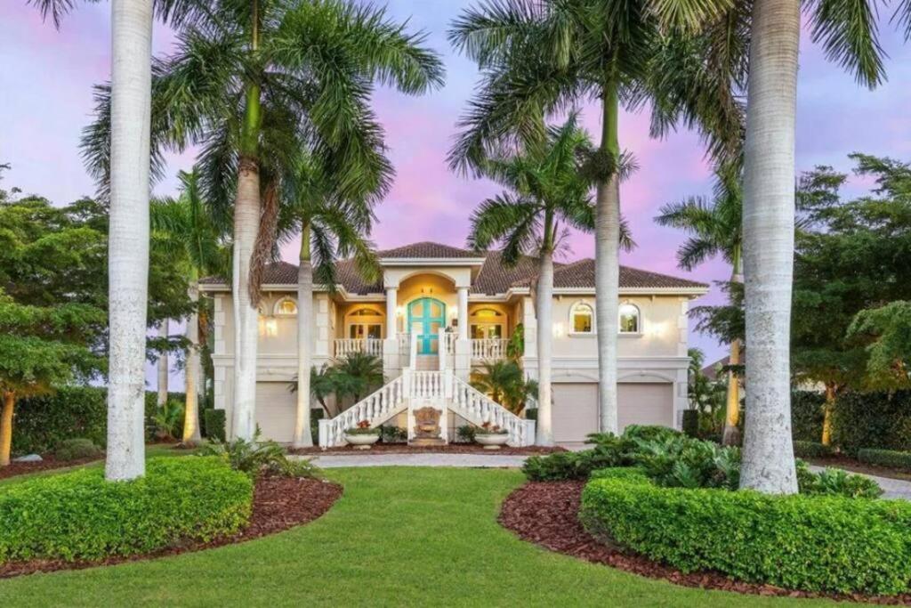 a large white house with palm trees at Tropical Pool Paradise - Minutes from the Beach Venice in Nokomis