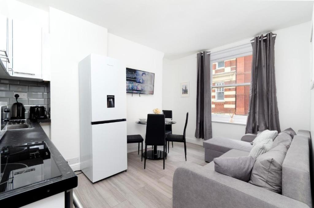 uma cozinha e sala de estar com um sofá e uma mesa em Strand Central Apartments em Londres