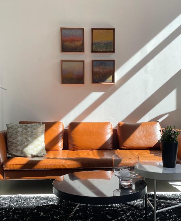 a brown couch in a living room with a table at Chambre d&#39;hôtes la Teinturerie in Roubaix