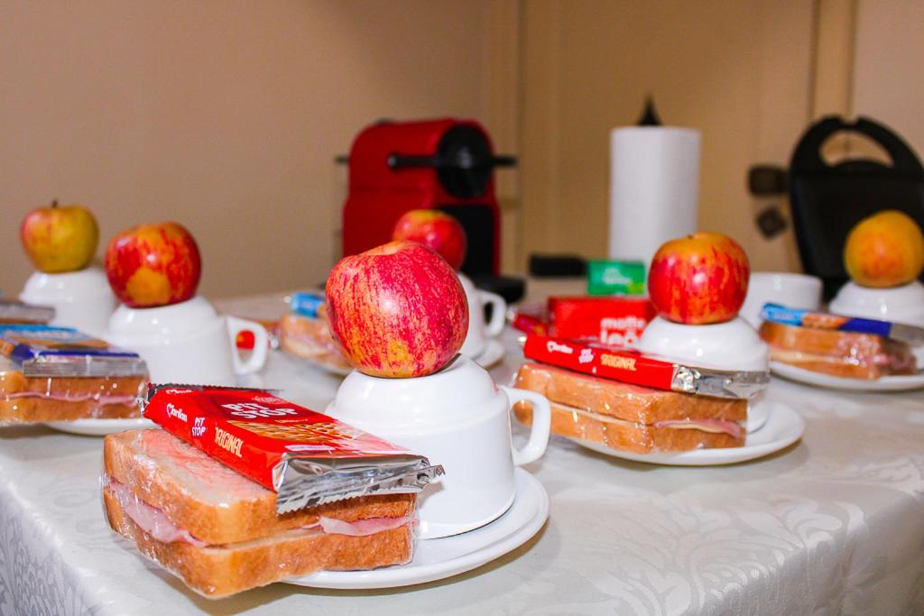 a table with sandwiches and apples on top of them at Nuh Hostel - Lourdes in Belo Horizonte