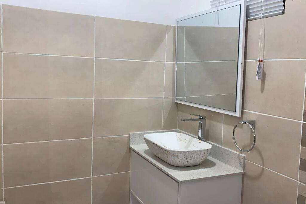 a bathroom with a sink and a mirror at Luxury 3-bedroom apartment in Accra