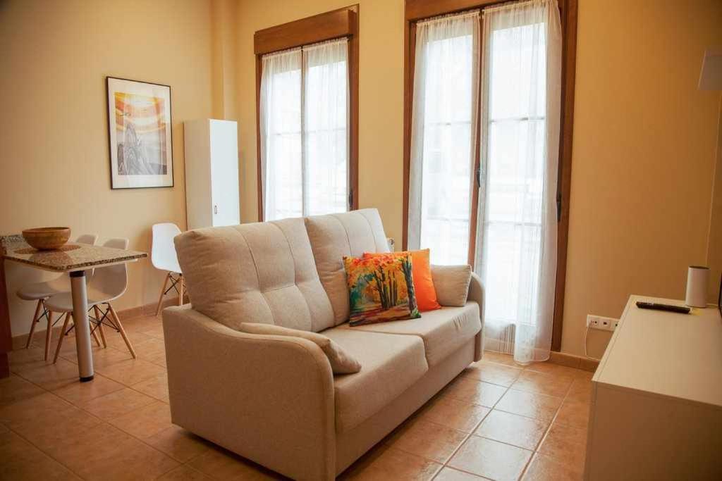 uma sala de estar com um sofá e uma mesa em Cumbres de los Picos Apartamento Treparriscos em Poo de Cabrales