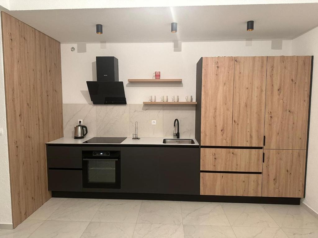 a kitchen with a sink and wooden cabinets at Dora in Posušje