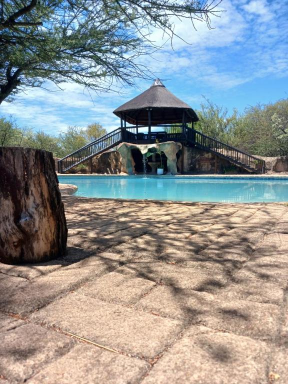 a bridge over a swimming pool with a gazebo at A1 Paradise Inn in Bobbejaanstert