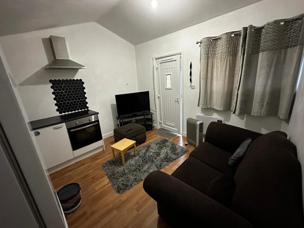 een woonkamer met een bank en een televisie bij 10B sunset park homes in Brackley