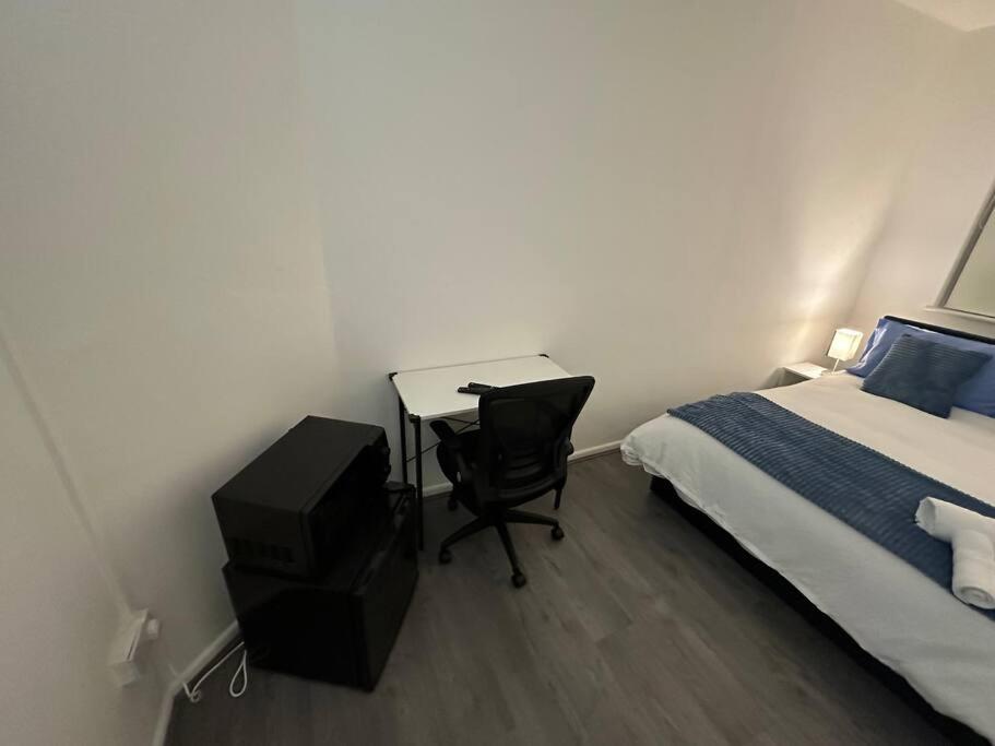 倫敦的住宿－Small cozy private bedroom zone1，一间卧室配有一张床和一张桌子,一张床铺和椅子