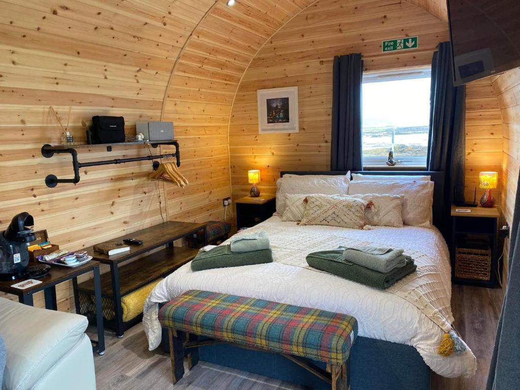 a bedroom with a bed in a wooden cabin at Waterloo Sunset in Breakish
