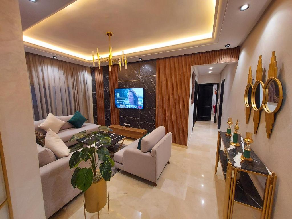 a living room with a couch and a tv at modern apartment opposite the Hassan2 mosque, very well equipped and stylish, 85 m² with gym and direct sea view with underground garage. (couple of Arab origin without marriage certificate will be refused) in Casablanca