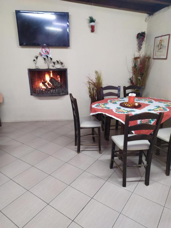 a dining room with a table and a fireplace at ΣΕΤΣΚΟΣ ΖΗΣΗΣ in Kato Loutraki