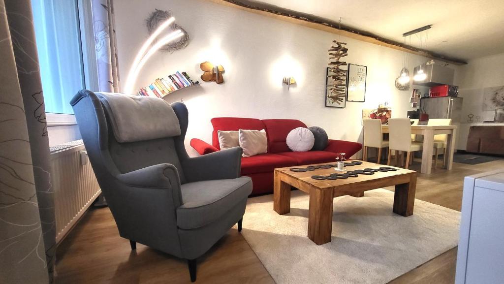 - un salon avec un canapé rouge et une table basse dans l'établissement Ferienwohnung Abenddämmerung Hahnenklee, à Hahnenklee