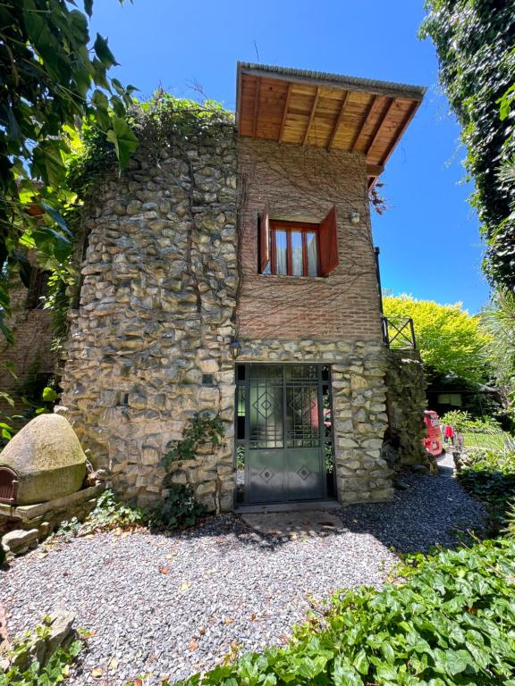 un edificio de piedra con puerta y ventana en Cabañas Arehue en Mar del Plata