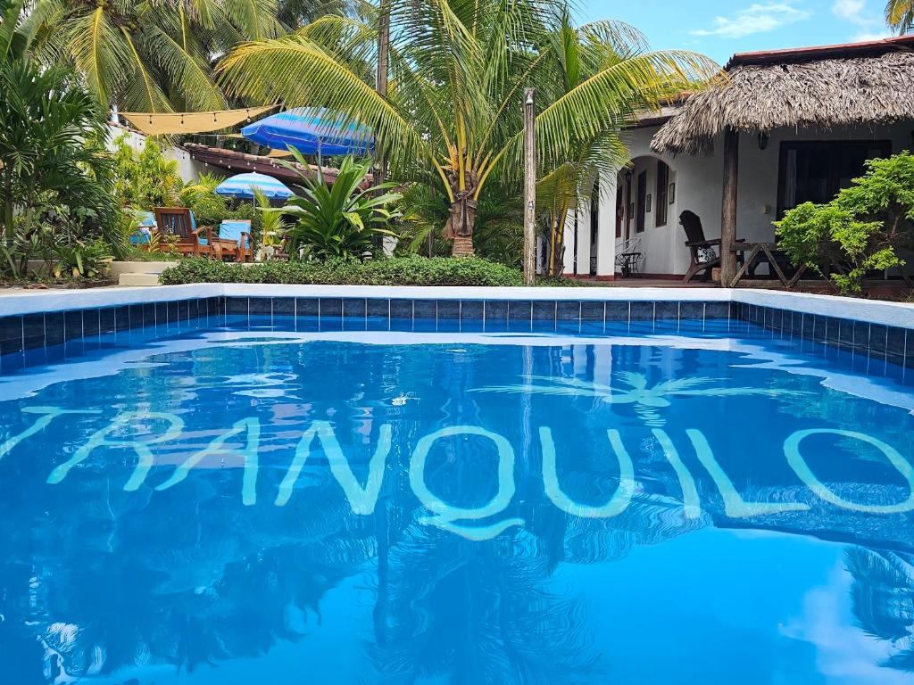 a swimming pool in front of a villa at Hotel Tranquilo in Las Peñitas