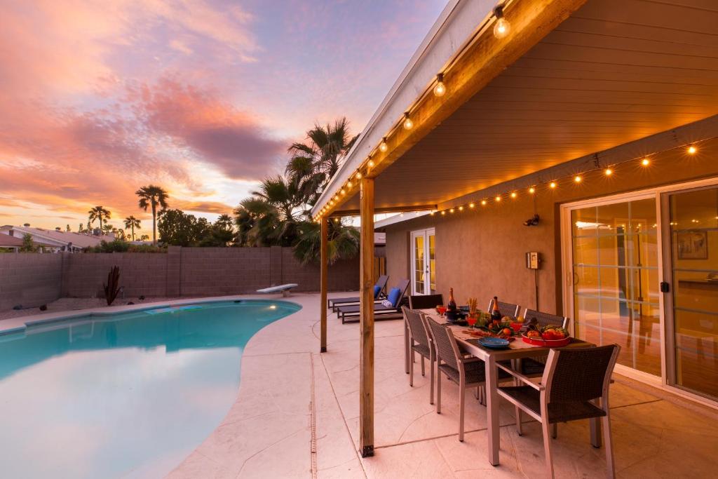 a patio with a table and chairs next to a swimming pool at West Ridge by AvantStay A Place Of Comfort Perfect Sunsets by the Pool ❤ in Scottsdale
