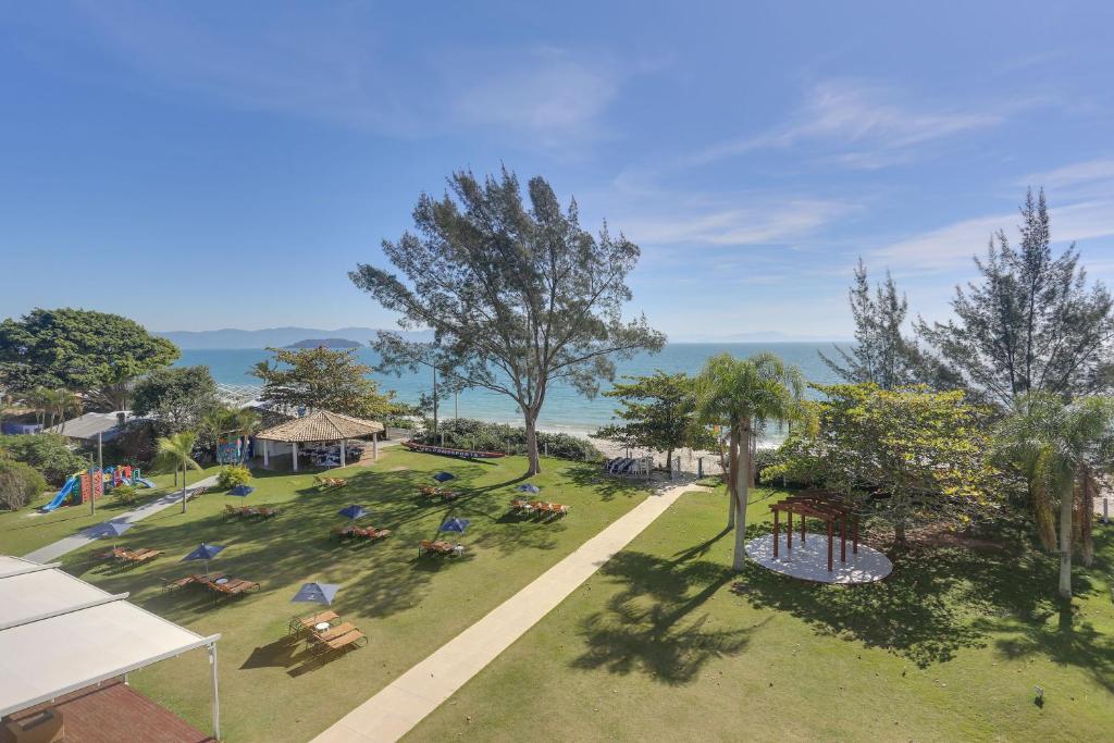 einen Blick über einen Park mit Stühlen und Bäumen in der Unterkunft Hotel Porto Sol Beach in Florianópolis