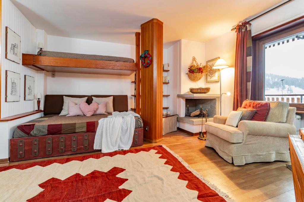ein Schlafzimmer mit einem Bett, einem Sofa und einem Kamin in der Unterkunft BeSt Riccio in Sestriere