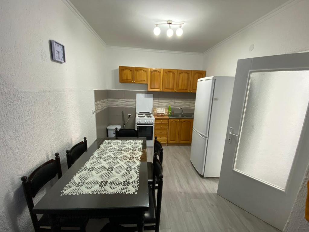 een keuken met een tafel en een witte koelkast bij Apartmani Popov in Vrbas