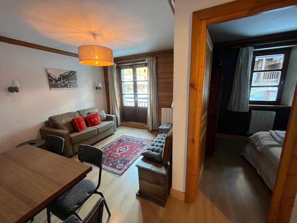 uma sala de estar com um sofá e uma mesa em Adorable 30m2 Coeur de Val 1 chambre 2 lits em Val dʼIsère