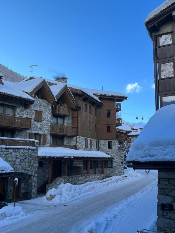 Une rue enneigée en face de certains bâtiments dans l'établissement Adorable 30m2 Coeur de Val 1 chambre 2 lits, à Val dʼIsère