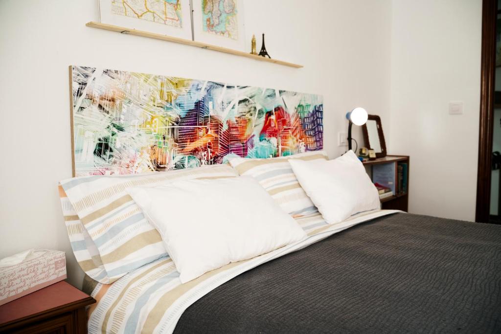 1 dormitorio con 1 cama con almohadas a rayas en Apartamento turístico Travelers, en Baena