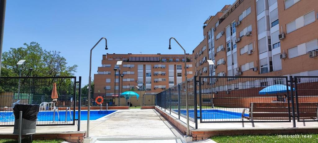 a swimming pool in front of a building at Habitación individual con baño privado en casa particular in Madrid