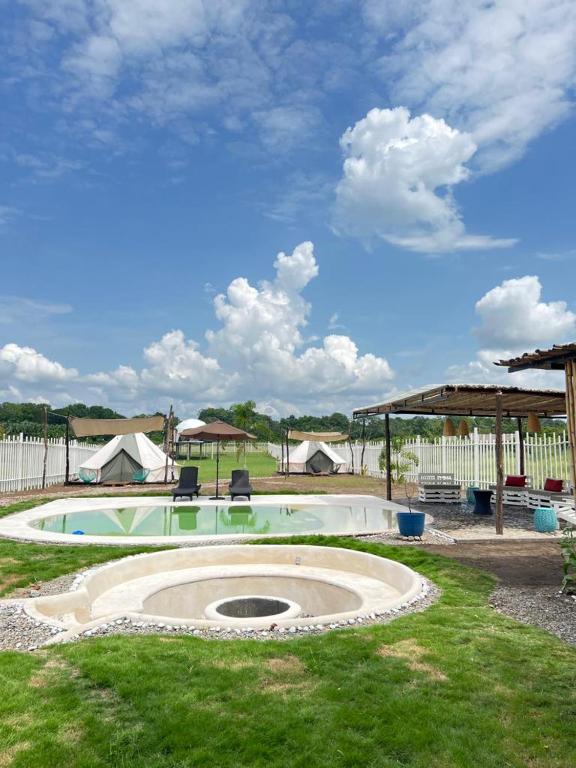 a swimming pool with two chairs in a yard at Dharma Glamping in Tapachula
