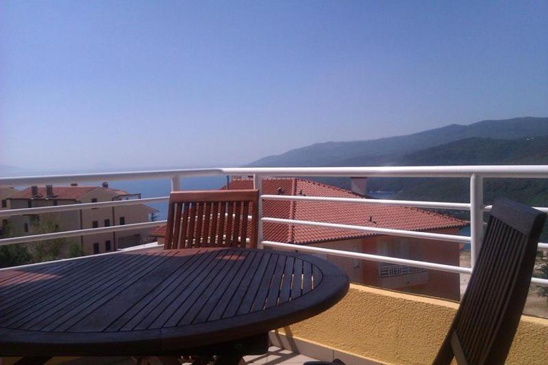 un tavolo e sedie su un balcone con vista sull'oceano di Apartment Braje Opatijska a Rabac