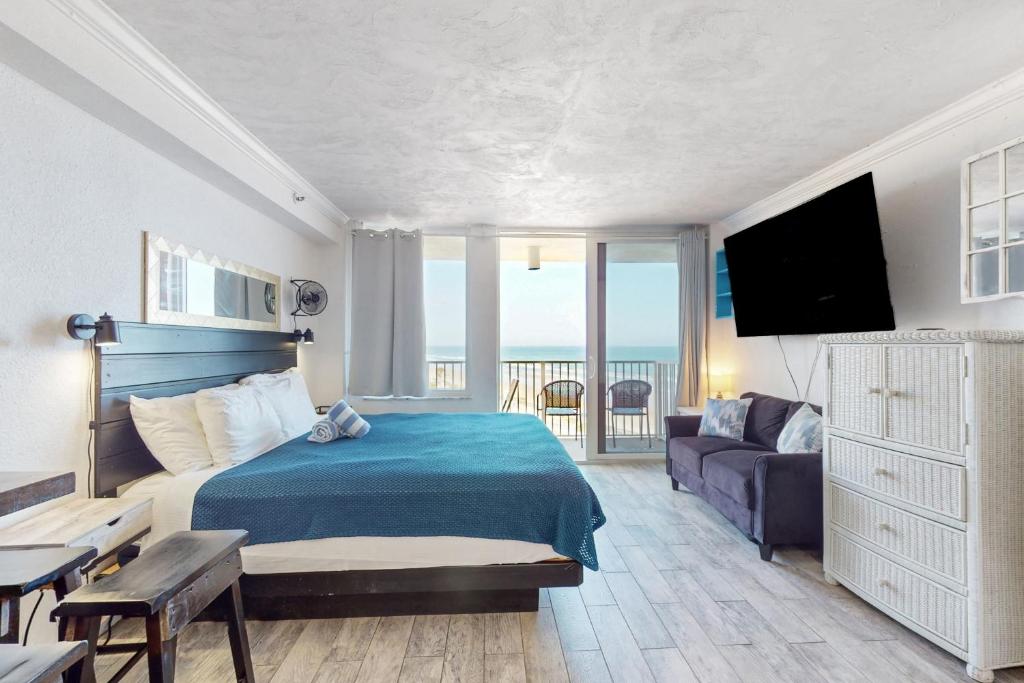 1 dormitorio con cama, sofá y TV en Harbour Beach Resort 618, en Daytona Beach