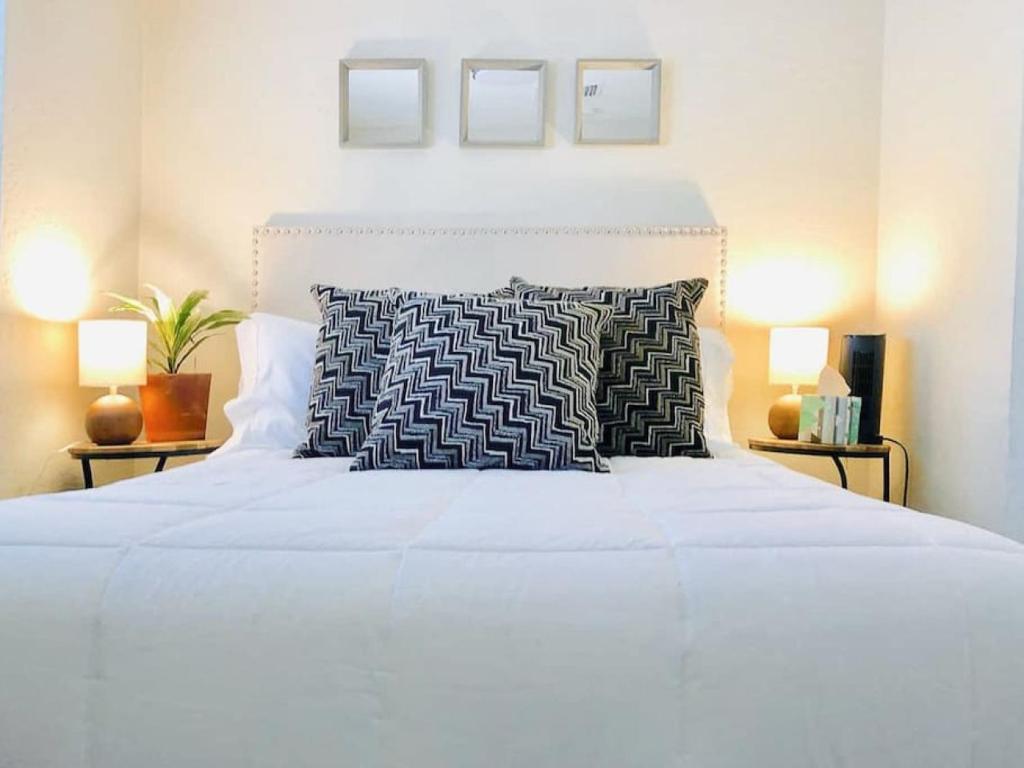 a bedroom with a large white bed with two lamps at Sunny Guest Suite with large backyard - Pets Welcome in Phoenix