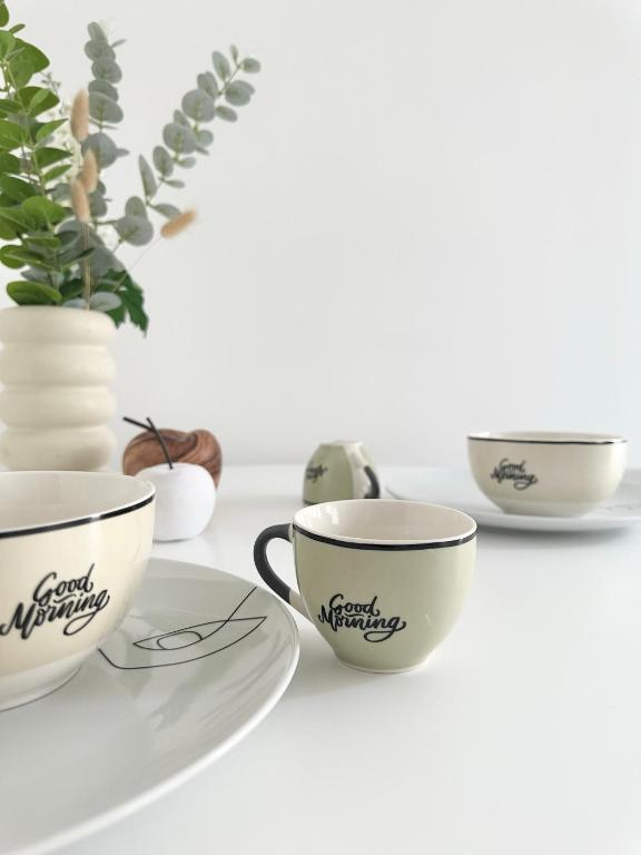 a group of cups and plates on a table at Logement Entier au Centre Ville in Évreux